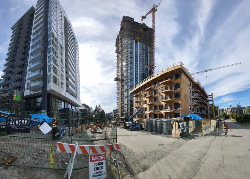 Two residential towers under construction, workers on site